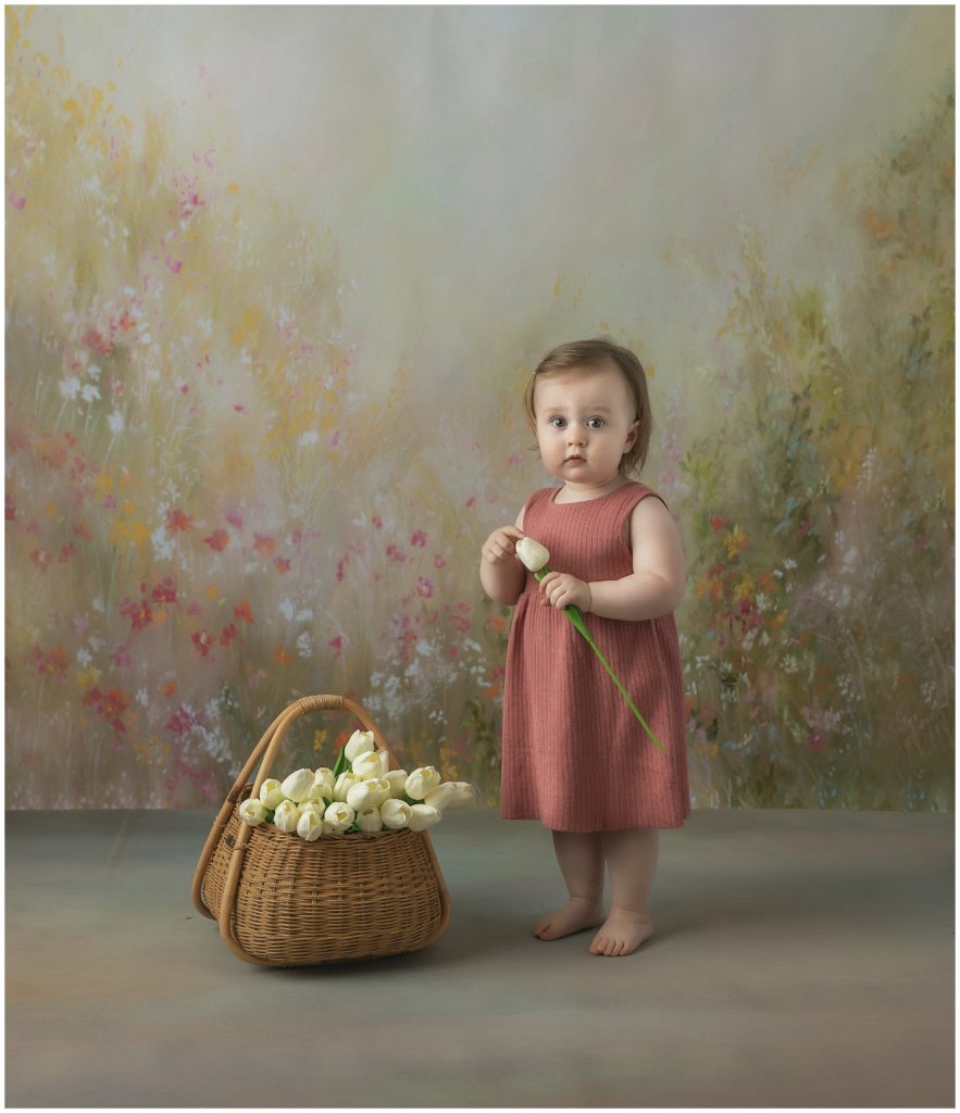 Portrait of toddler girl in coral dress with tulips.