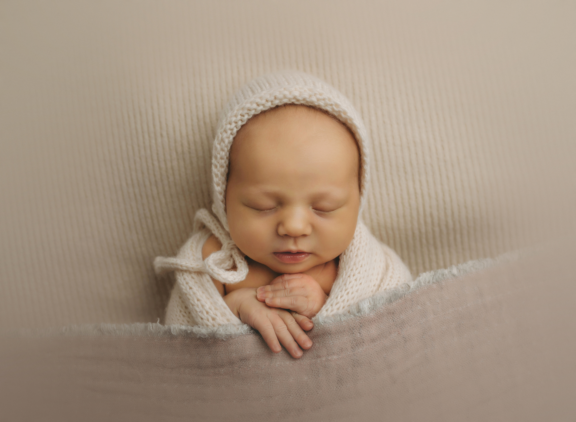 Newborn baby in white bonnet