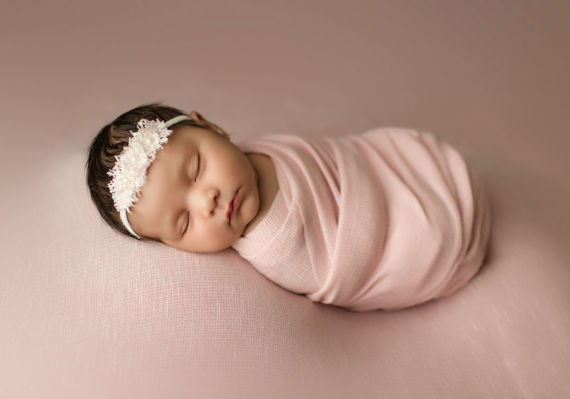 Newborn baby girl portrait on blush pink