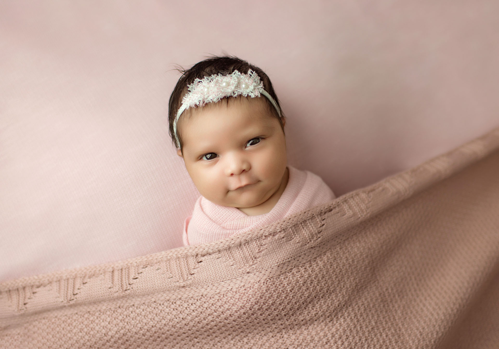 Newborn baby girl portrait on blush pink