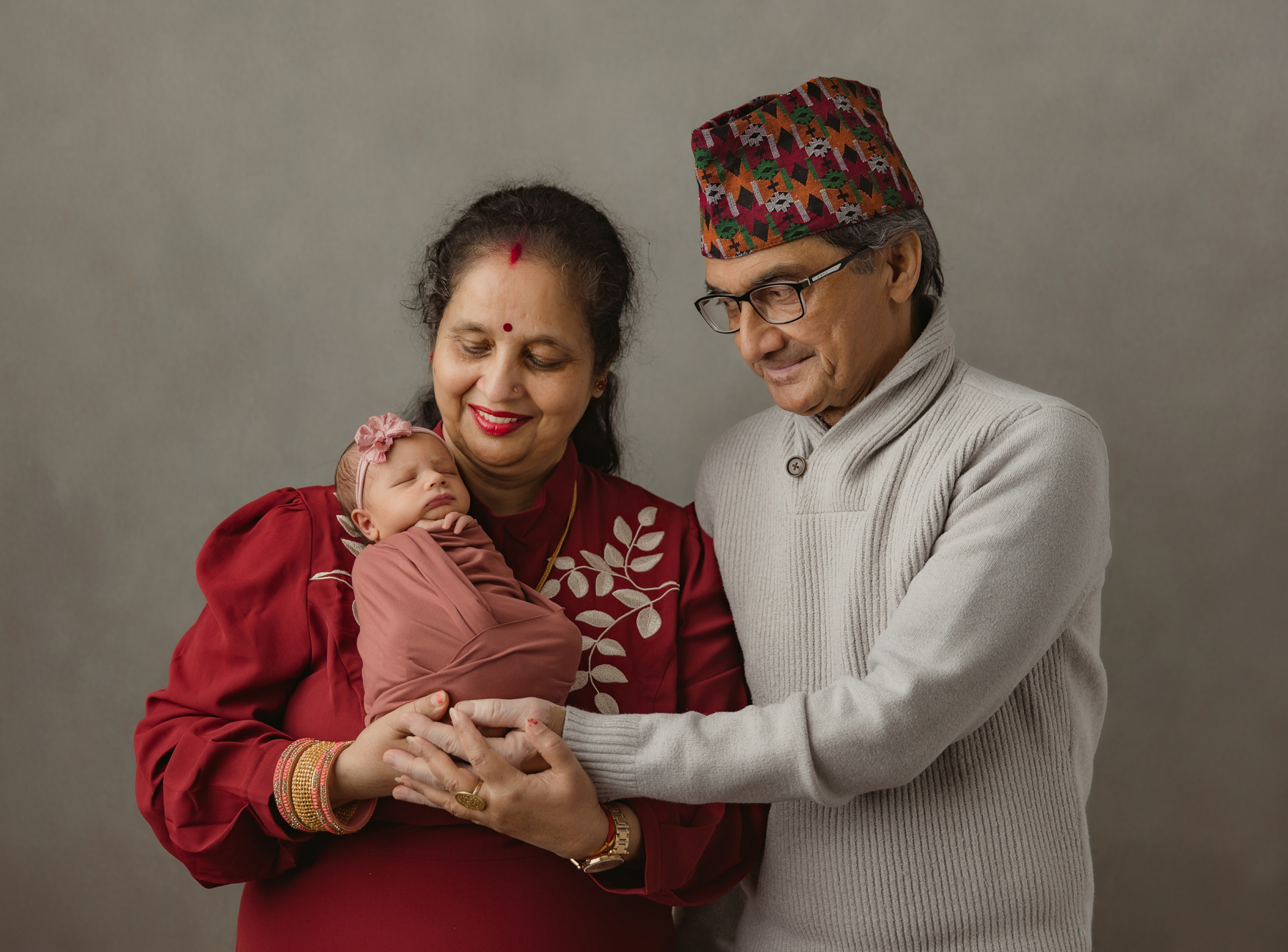Grandparents holding newborn baby