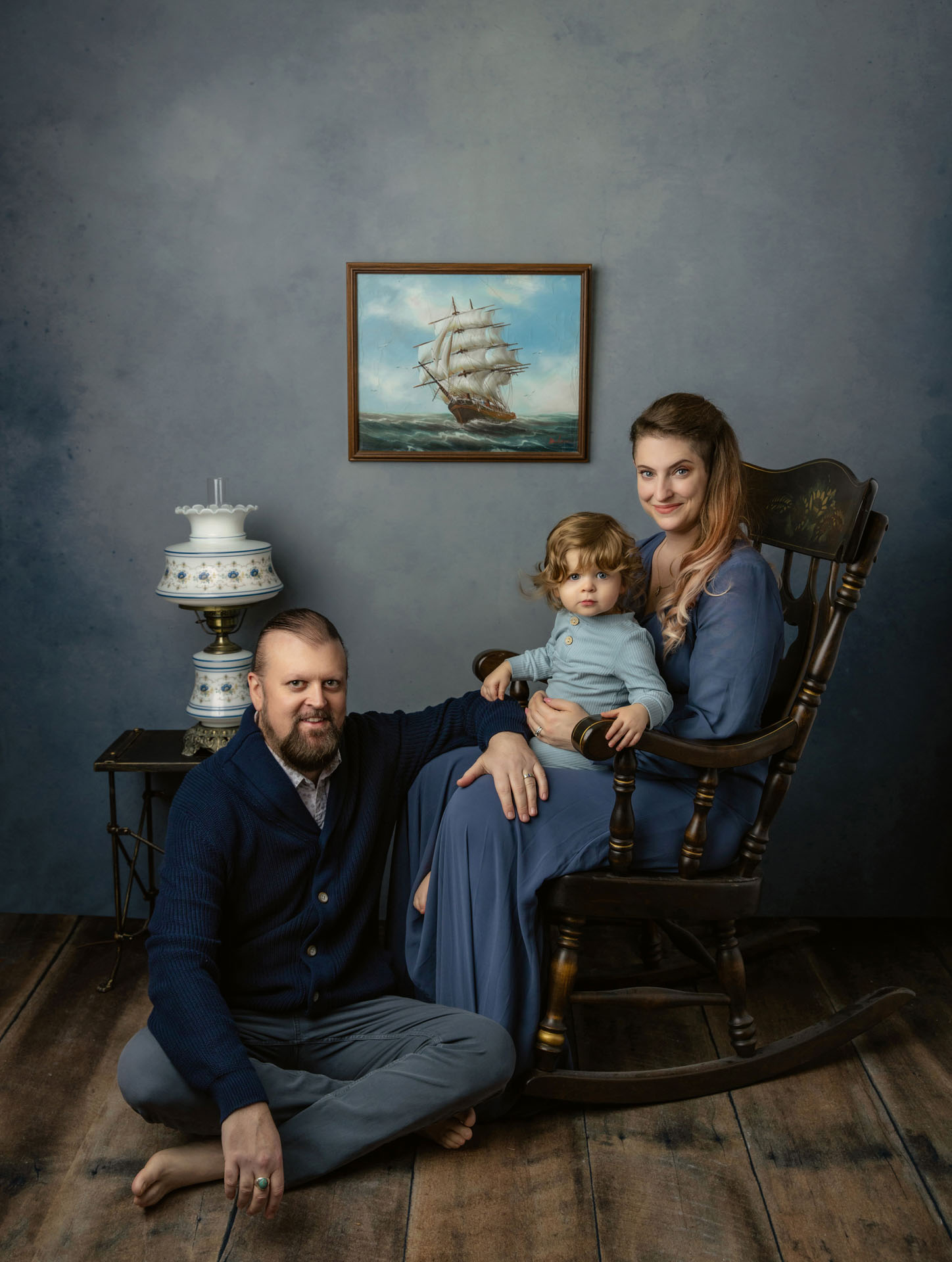 Portrait of mom and toddler in rocking chair with dad