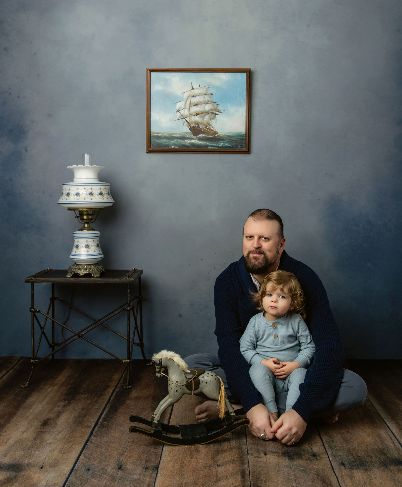 Portrait of dad playing with toddler and rocking horse on floor