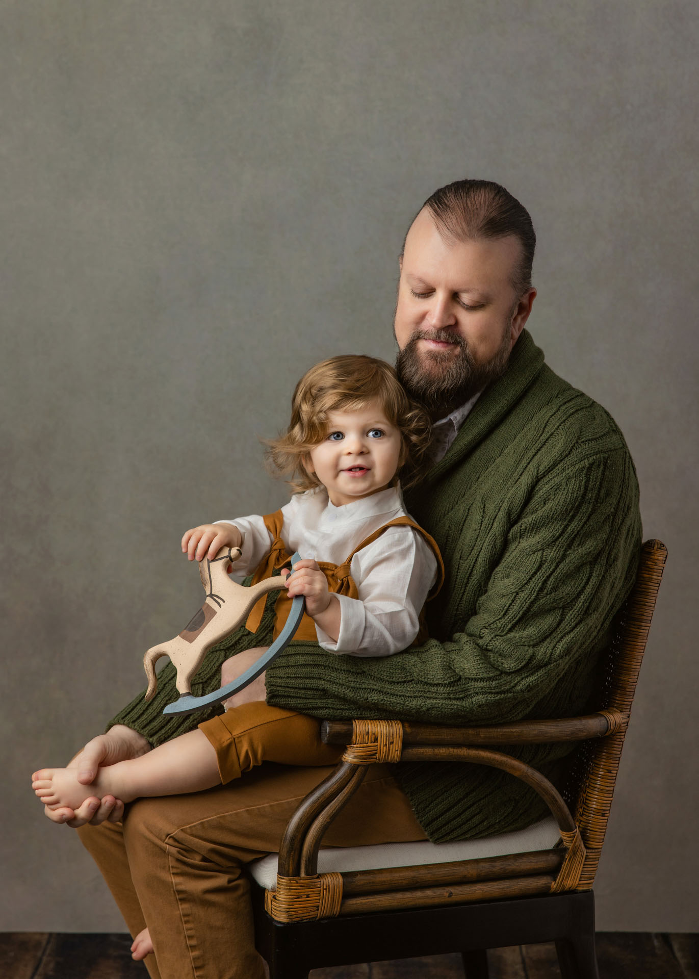 Portrait of toddler boy sitting on dad's lap