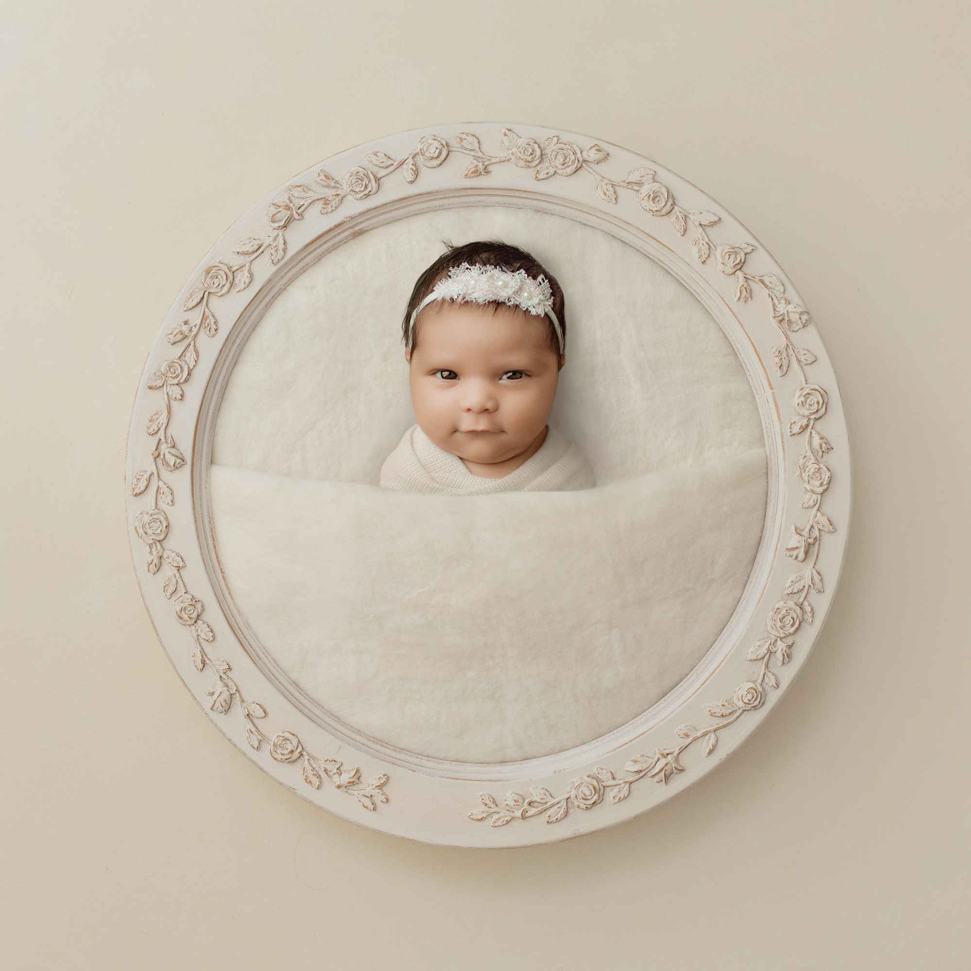 Newborn baby in cream frame portrait