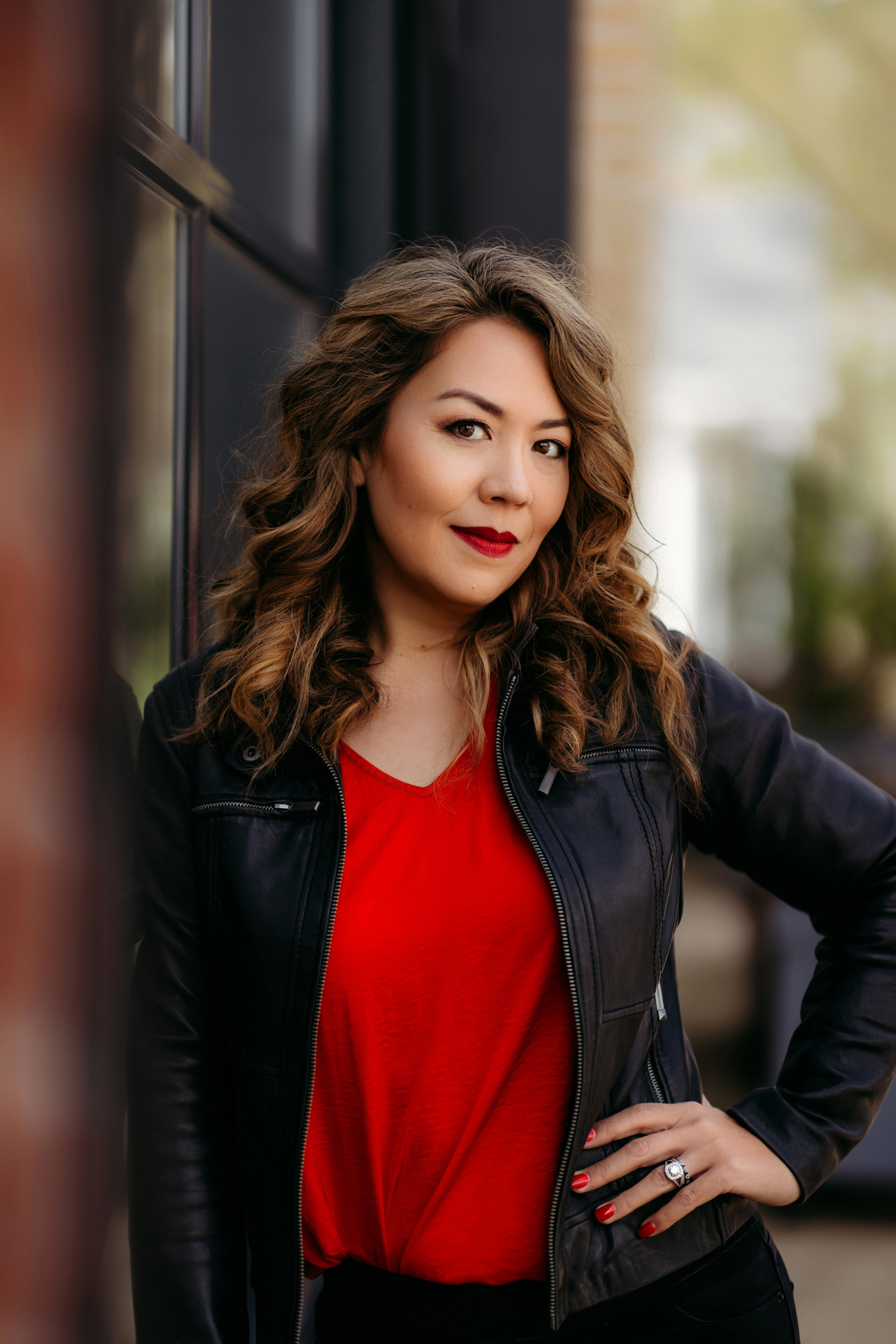 Professional opera singer headshot of woman in red shirt and leather jacket